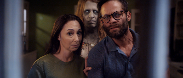 Ghostly apparition looming behind an unsuspecting couple in a tense scene from the Kid Paranormal film.